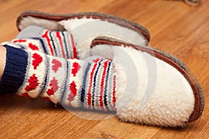 Woman feet in knitted socks and fluffy slippers