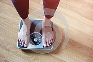 Woman feet look Lose weight concept on a scale kilograms on floor background-Diet concept