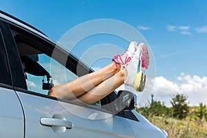 Woman feet relaxing and is off the car window