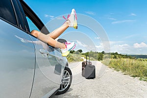 Woman feet relaxing and is off the car window