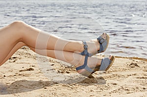 Woman feet in sandals on the beach