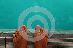 Woman feet stand on wooden bridge over sea. Vacation holiday enjoying sun on sunny summer day concept.