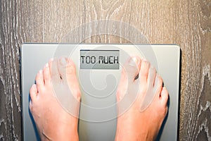 Woman feet stepping on a weight scale having problems with her diet