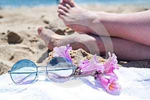 Upside woman feet and red pedicure wear pink sandals, sunglasses at seaside. Funny and happy fashion young woman relax on vacation