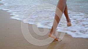 Woman feet walking ocean waves closeup. Unknown playful girl enjoying beach