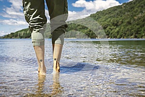 Woman feet in water with her legs tattooed with 2 hearts