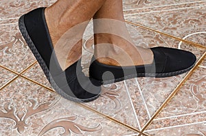 Woman Feet Wearing A Pair Of Black Sneakers