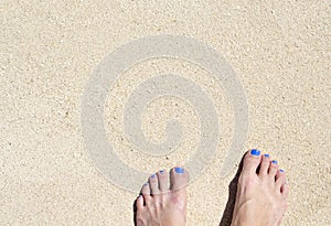 Woman feet on white beach sand. White sand top view photo for background.