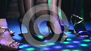 Woman feets on high heels synchronously tap on floor. Fashion show in nightclub.