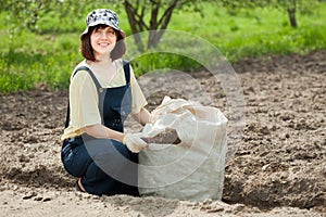 Woman fertilizes soil