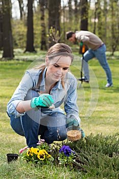 Woman fertilizing flowers