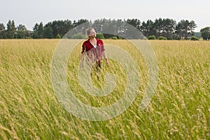 a woman in a field with her beloved pet on a walk.