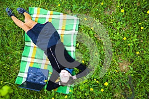 Woman in field with laptop