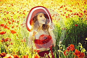 Woman in field of poppy seed in retro hat