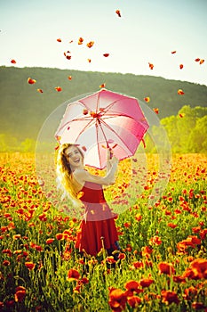 Woman in field of poppy seed with umbrella