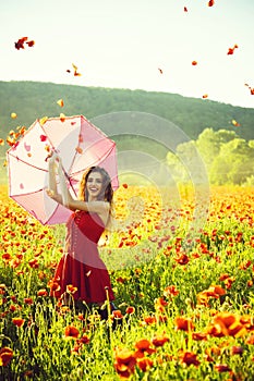 Woman in field of poppy seed with umbrella