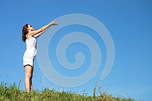 Woman in field under blue sky