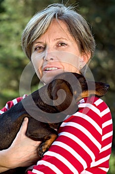 Woman in fifties holding a dog photo