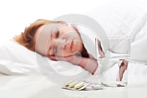 Woman fighting sickness with pills and resting