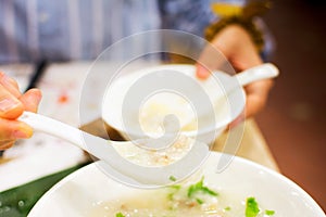 Woman fill a bowl with porridge photo