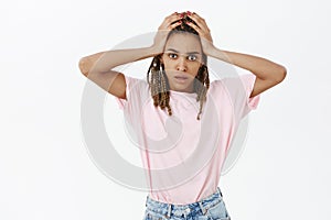 Woman filled up with pressure and responsibilities standing tired and concerned against grey wall in stylish pink t