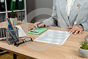 Woman filling 1040 tax forms with laptop pen and calculator at office