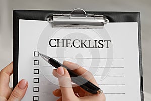 Woman filling Checklist with pen, closeup view