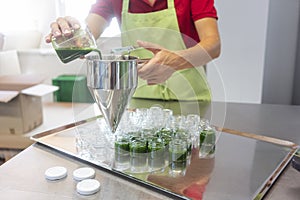 Woman filling wheatgrass smoothie in glasses