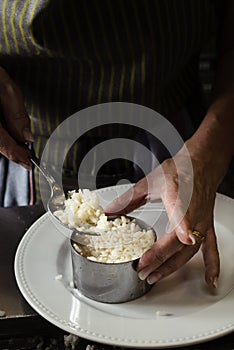 Woman filling a mold with cooked rice