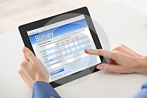 Woman Filling Online Survey Form On Digital Tablet