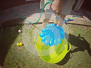 Woman filling up water balloons.