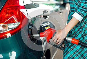 Woman fills petrol into the car at a gas station