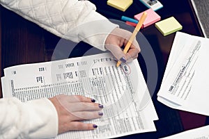 Woman fills the tax form, working with tax documents. Form 1040 Individual Income Tax return form. United States Tax forms.