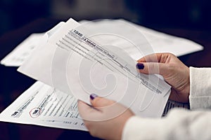 Woman fills the tax form, working with tax documents. Form 1040 Individual Income Tax return form. United States Tax forms.