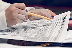 Woman fills the tax form, working with tax documents. Form 1040 Individual Income Tax return form. United States Tax forms.