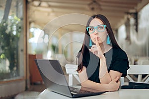 Woman With Finger on the Lips Looking at Laptop photo