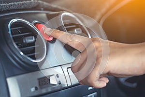 Woman finger pressing emergency button on car dashboard