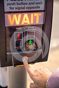 Woman finger pushing pedestrian crossing signal