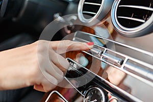 Woman finger tap a button in car