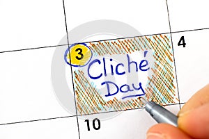 Woman fingers with pen writing reminder Cliche Day in calendar photo