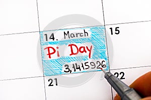 Woman fingers with pen writing reminder Pi Day in calendar.