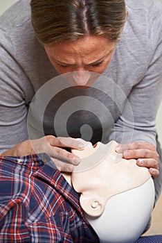 Woman In First Aid Class Performing Mouth To Mouth Resuscitation