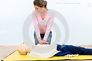 Woman in first aid course practicing heart massage