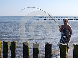 Woman with fish and fishing-rod