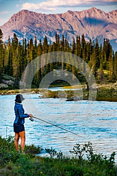 A woman fishing in Alberta\'s North Saskatchewan River, Canada
