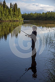 Woman fishing in river in summer