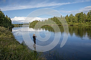 Woman fishing in river in summer