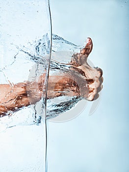Woman Fist through the Blue Water and splashing drops