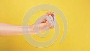 Woman fist. gesture threatens and aggression on isolated yellow background