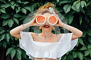 Woman fit girl holding two halfs of grapefruit